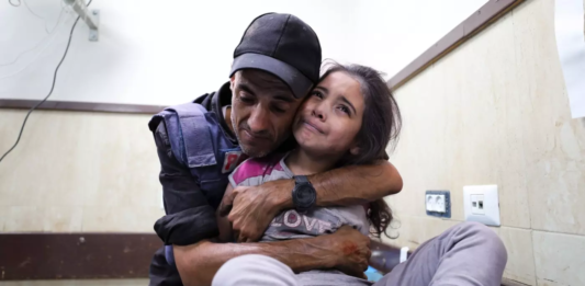 a Reporter in Gaza is Hugging a Young Woman in a Room in Gaza's Al-quds Hospital