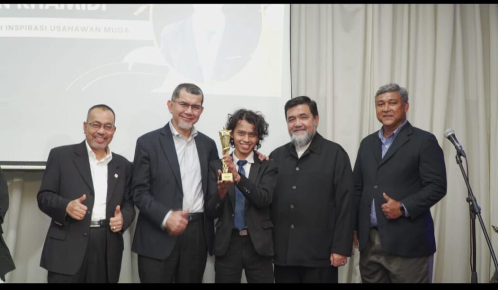 Ahmad Zulfadzli Bin Khamidi Menerima Anugerah Inspirasi Usahawan Sambil Bergambar Bersama Barisan Kepimpinan Kanan Yayasan Uniti Selepas Majlis Penyampaian Anugerah Umec.